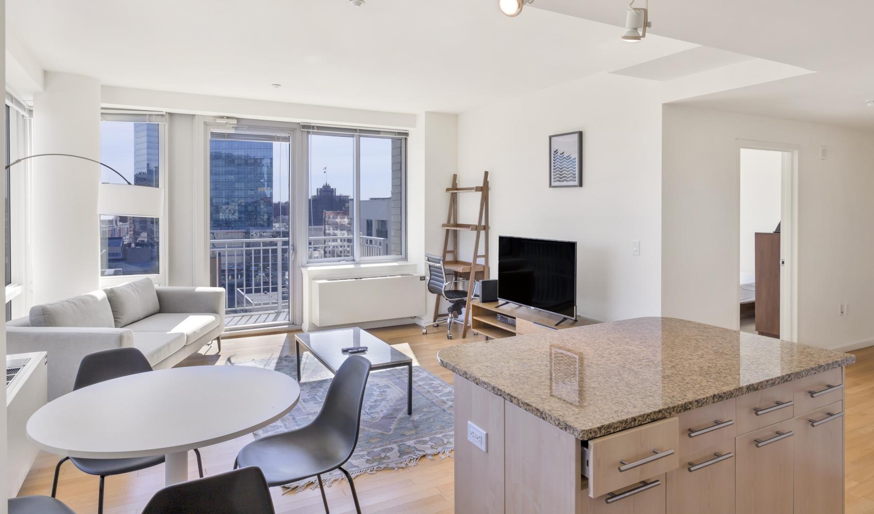a living room with a couch, tv, table and chairs