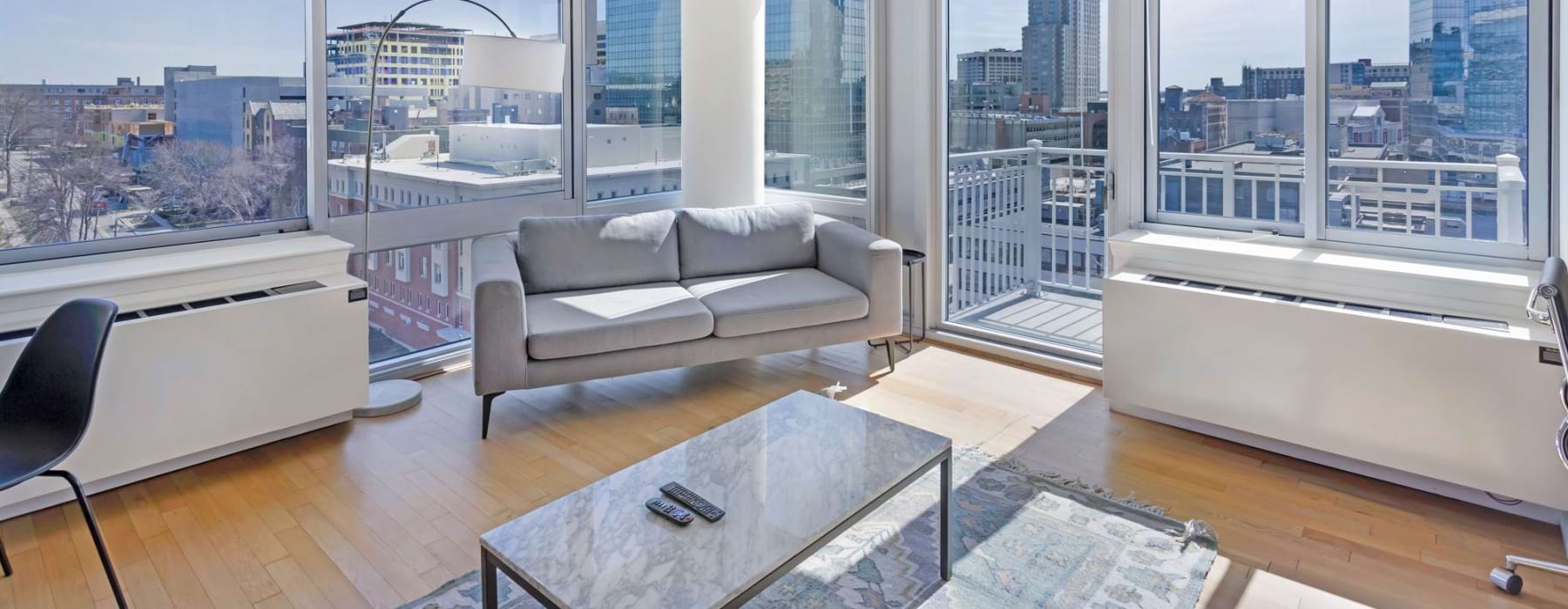 sun-filled living room with large windows and city views